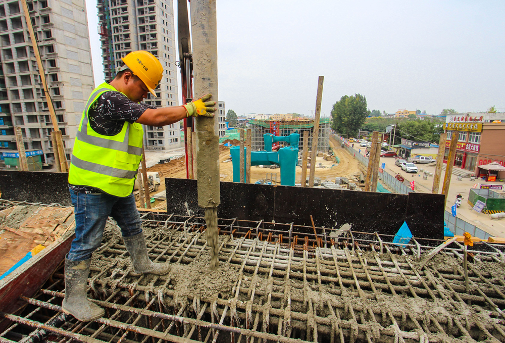 中国十七冶集团公司南阳项目部建设工地,农民工在高架桥上浇筑混凝土.