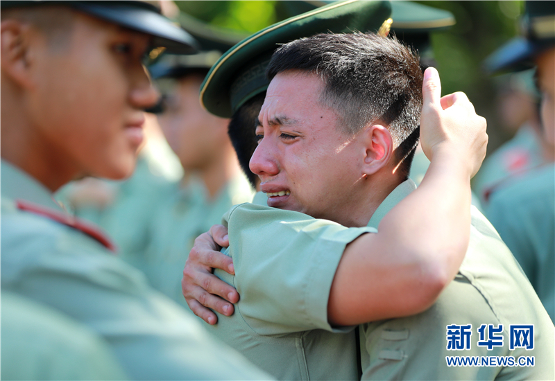 8月31日,武警三亚支队退伍老兵与留队战友挥泪拥抱新华网发(周奕 摄)